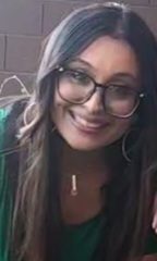 A smiling woman with glasses and long hair.