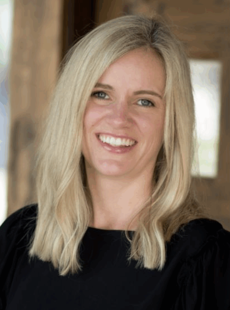 Smiling woman with blonde hair and black top.