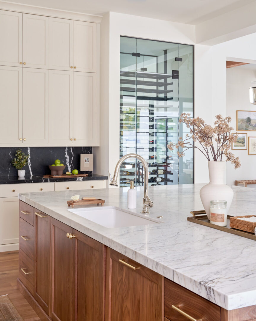 Modern kitchen with marble island and built-in wine storage.