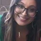 A smiling woman with glasses and long hair.