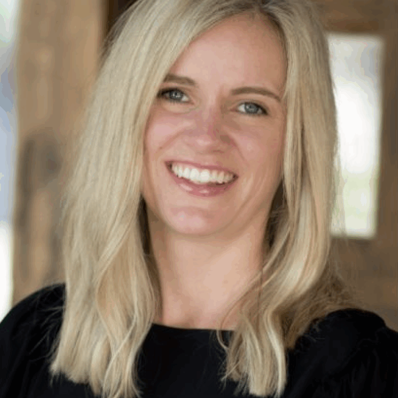 Smiling woman with blonde hair and black top.