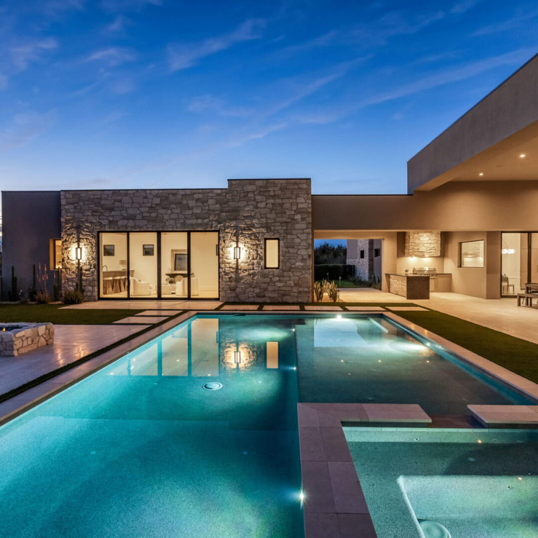 Modern house with a sleek pool under a twilight sky.